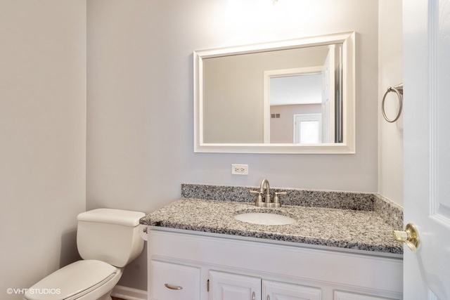 546 North Rohlwing Road Palatine, IL 60074 - Photo 6 of 17 a bathroom with a granite countertop toilet sink and mirror