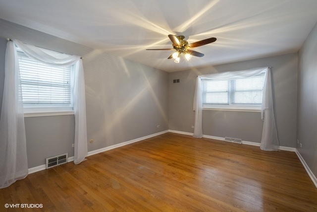 546 North Rohlwing Road Palatine, IL 60074 - Photo 7 of 17 a view of an empty room with wooden floor and a window
