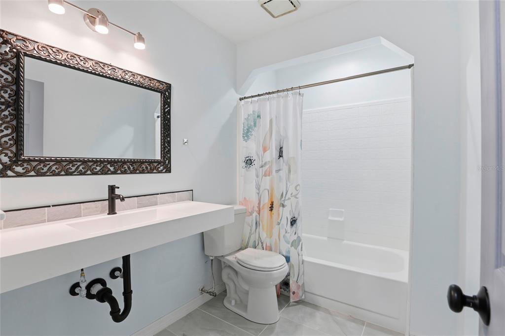 10808 Northwest 31st Place Gainesville, FL 32606 - Photo 23 of 38 a bathroom with a sink a toilet and shower