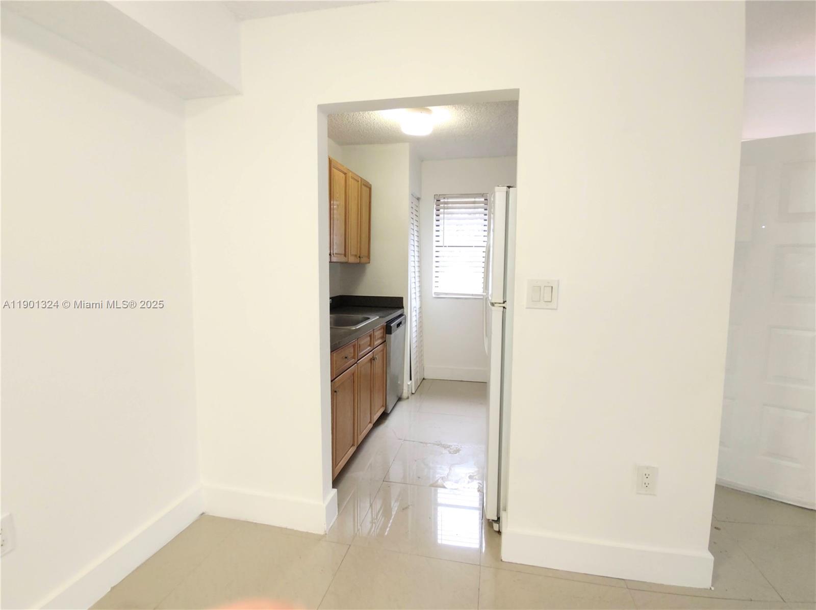 15500 Southwest 80th Street, Unit A105 Miami, FL 33193 - Photo 24 of 36 a view of a kitchen from the hallway