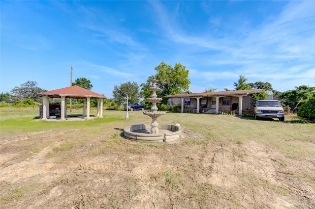 a view of a dry yard with wooden fence