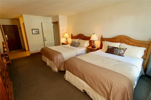 a bedroom with two beds and a night stand