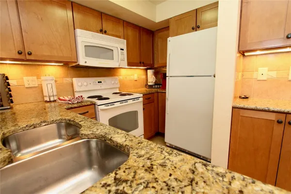 a kitchen with a refrigerator sink and cabinets