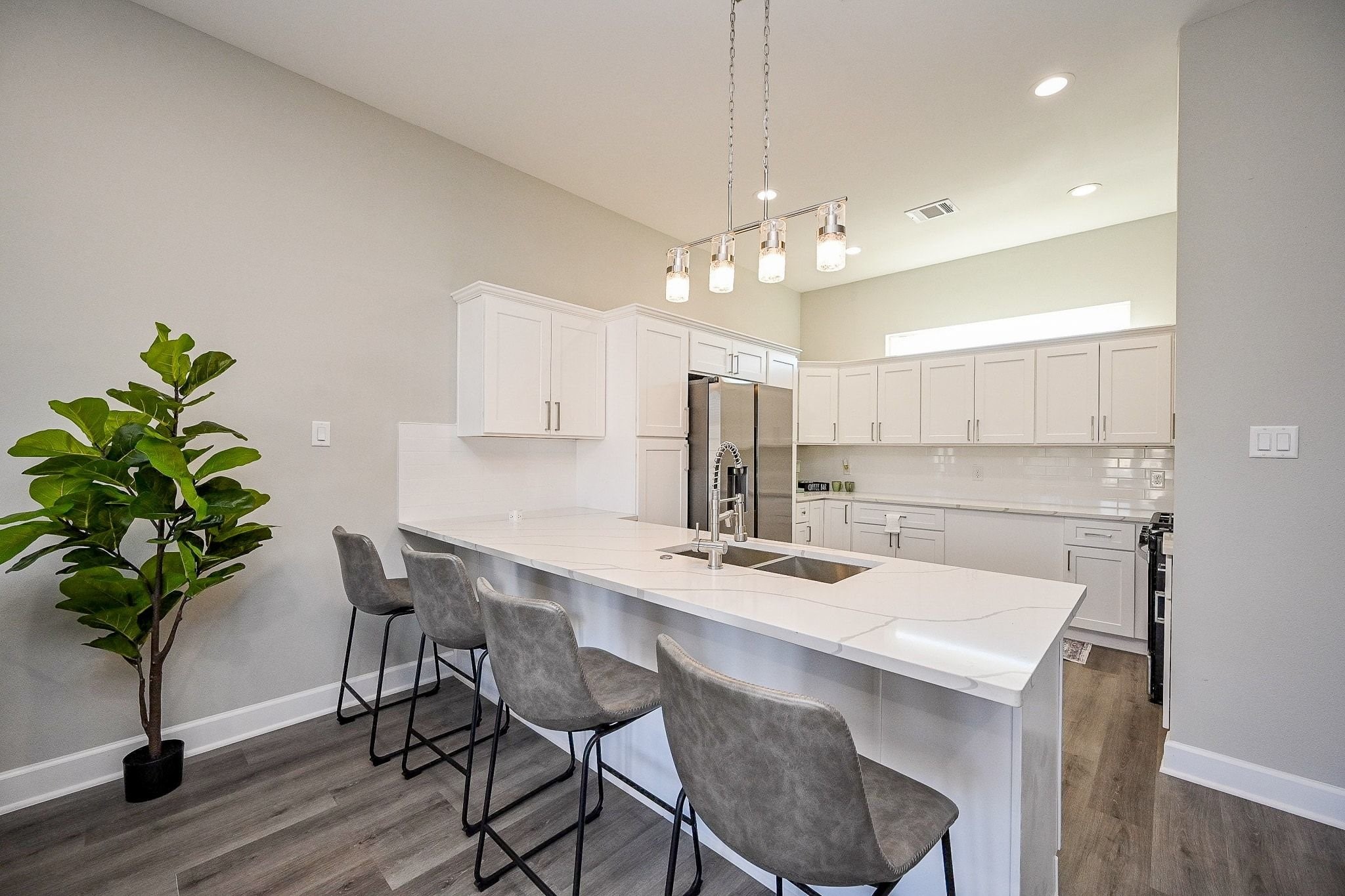 4746 Mallow Street Houston, TX 77033 - Photo 5 of 38 Sleek modern kitchen featuring a spacious peninsula and stylish pendant lighting.