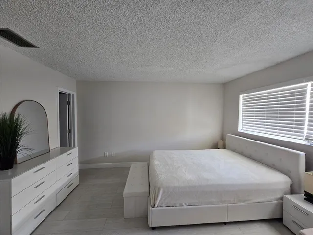 a bedroom with a bed and a dresser with mirror