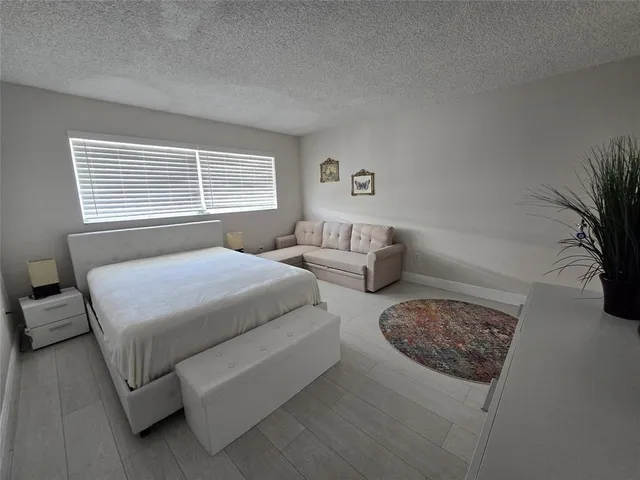 a bedroom with bed couch and window