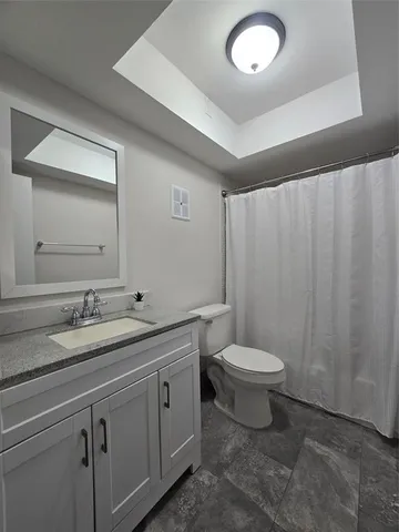 a bathroom with a toilet a sink and mirror