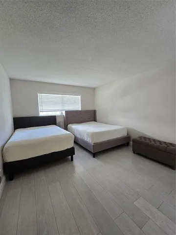 a bedroom with two beds and a night stand