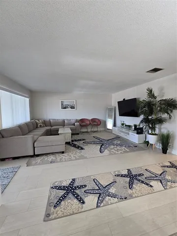 a living room with furniture flat screen tv and potted plant