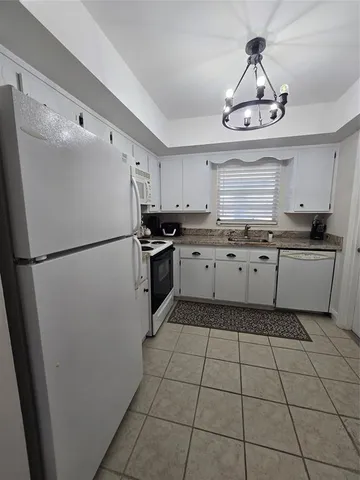 a kitchen with granite countertop stainless steel appliances a sink and a refrigerator