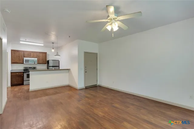 a view of kitchen with refrigerator and microwave