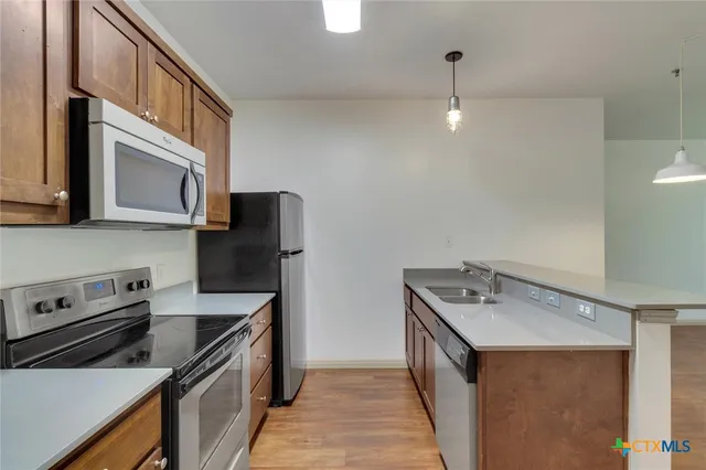 a kitchen with stainless steel appliances granite countertop a sink and a stove
