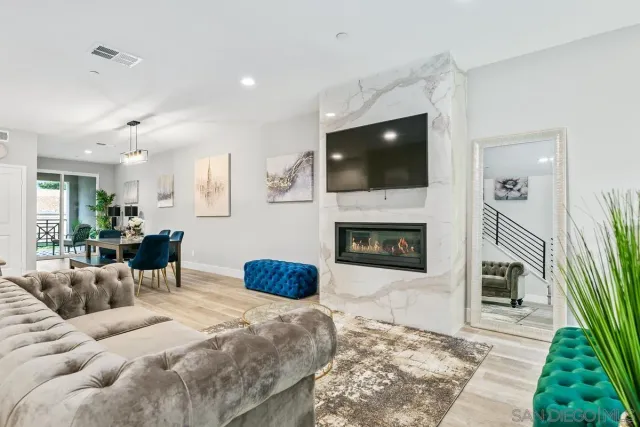 a living room with furniture a flat screen tv and a fireplace