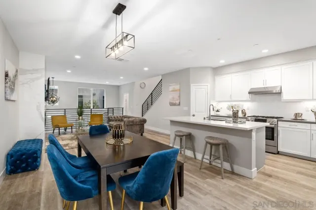 a kitchen with stainless steel appliances kitchen island granite countertop a sink a stove a dining table and chairs