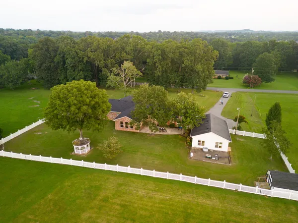 a kitchen with stainless steel appliances granite countertop a table chairs sink refrigerator and cabinets