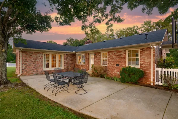 a view of a kitchen with kitchen island a sink a counter top space cabinets a stove and a window