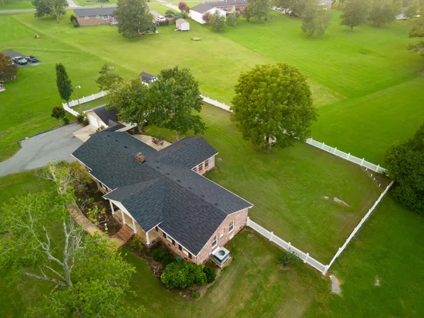 a kitchen with stainless steel appliances kitchen island granite countertop a stove a sink a dining table and chairs with wooden floor