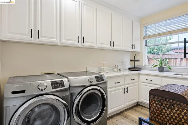 a utility room with sink dryer and washer