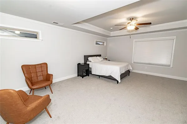 a spacious bedroom with a bed and ceiling fan