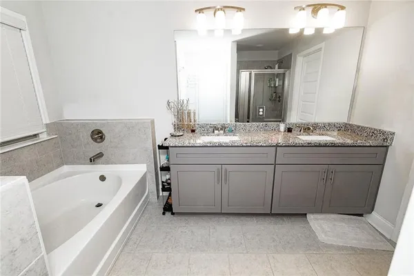 a spacious bathroom with a tub sink and mirror