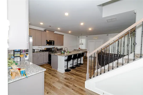 a kitchen with stainless steel appliances kitchen island granite countertop a refrigerator and a sink