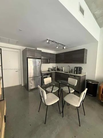 a workspace with furniture and kitchen view