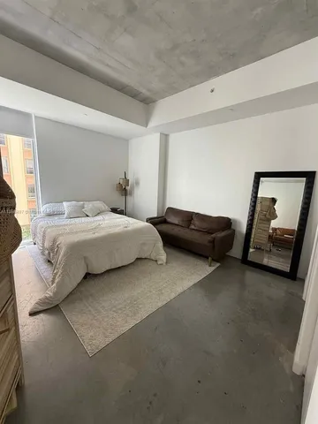 a bedroom with a bed and a mirror