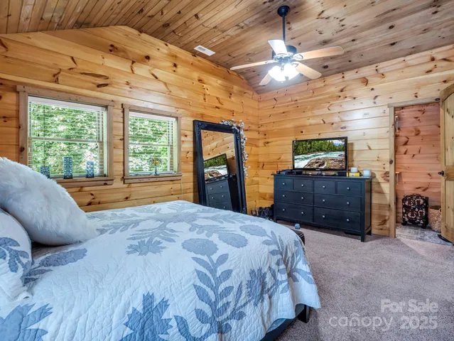a spacious bedroom with a bed and a dresser