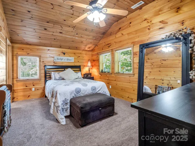 a bedroom with a bed and large windows