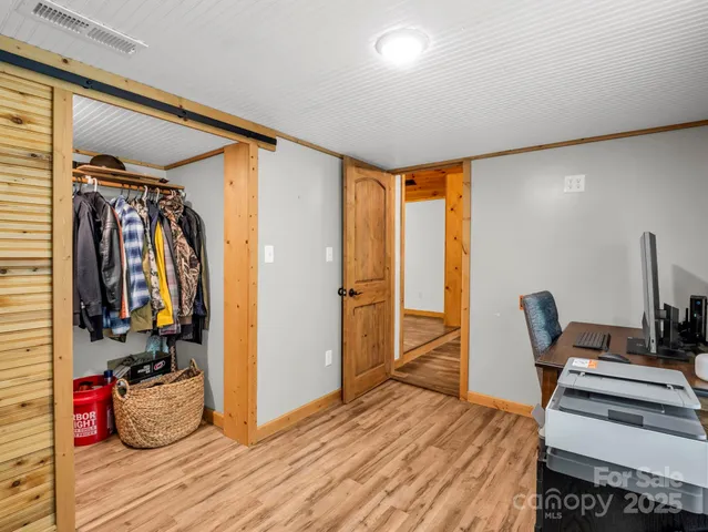a view of a room with wooden floor and furniture