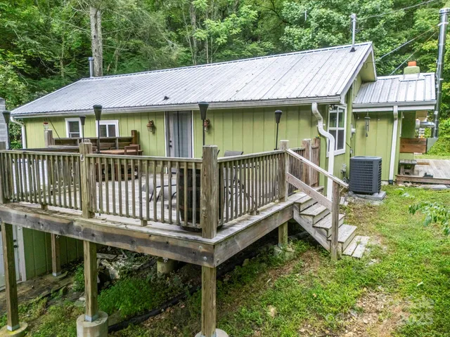 a view of a house with a wooden deck and furniture