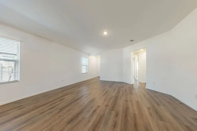 a kitchen with a wooden floor and window