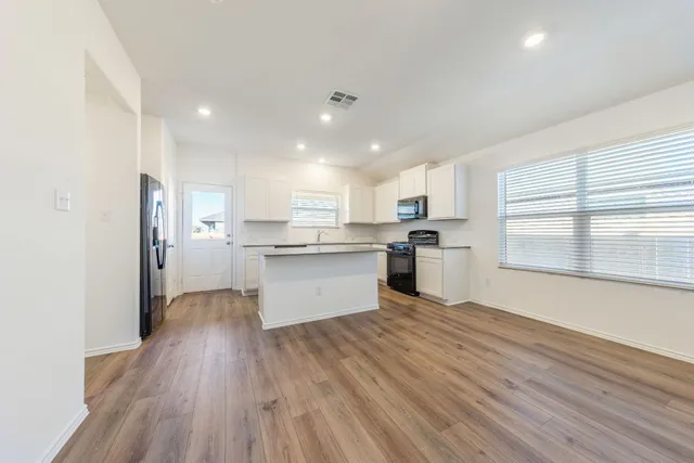 a kitchen with stainless steel appliances granite countertop wooden cabinets granite counter tops and a hard wood floors