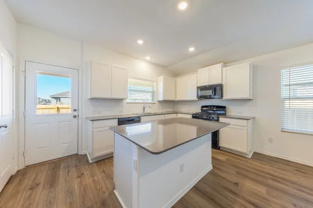 a kitchen with granite countertop a stove and a sink
