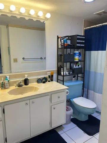 a bathroom with a granite countertop toilet sink and mirror