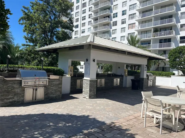 a patio with a table and chairs and potted plants