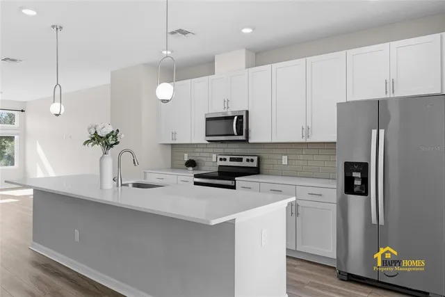 a kitchen with a sink a microwave a refrigerator and cabinets