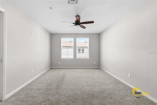 an empty room with windows and fan