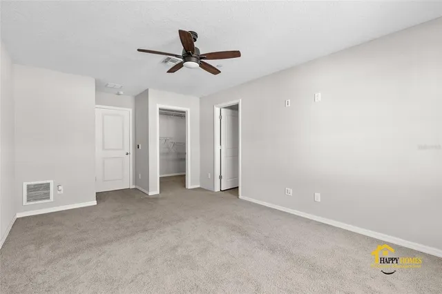 a view of a livingroom with a ceiling fan & window