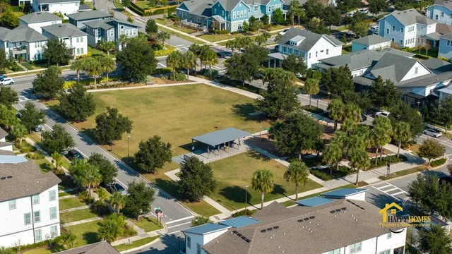 an aerial view of ocean and residential houses with outdoor space