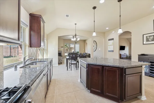 a kitchen with stainless steel appliances granite countertop a sink refrigerator and cabinets
