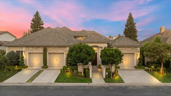 a front view of a house with a yard and outdoor seating