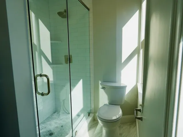 a bathroom with a toilet and a shower