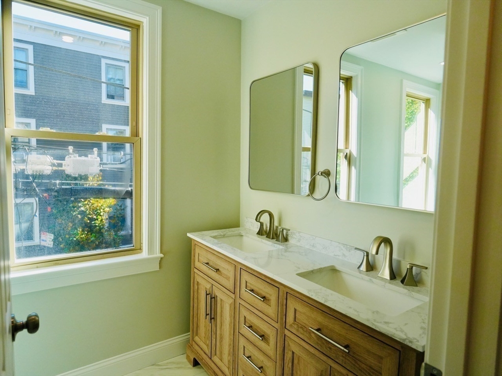 59 7th Street, Unit 3 Cambridge, MA 02141 - Photo 12 of 16 a bathroom with a granite countertop sink and a mirror