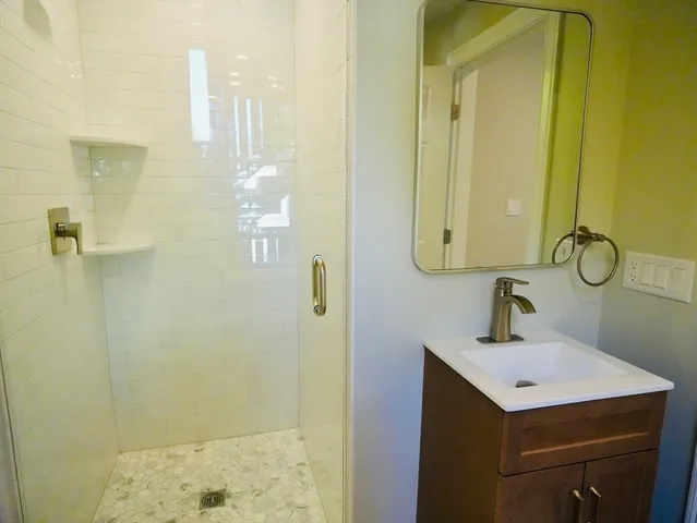 a bathroom with a sink a mirror and shower