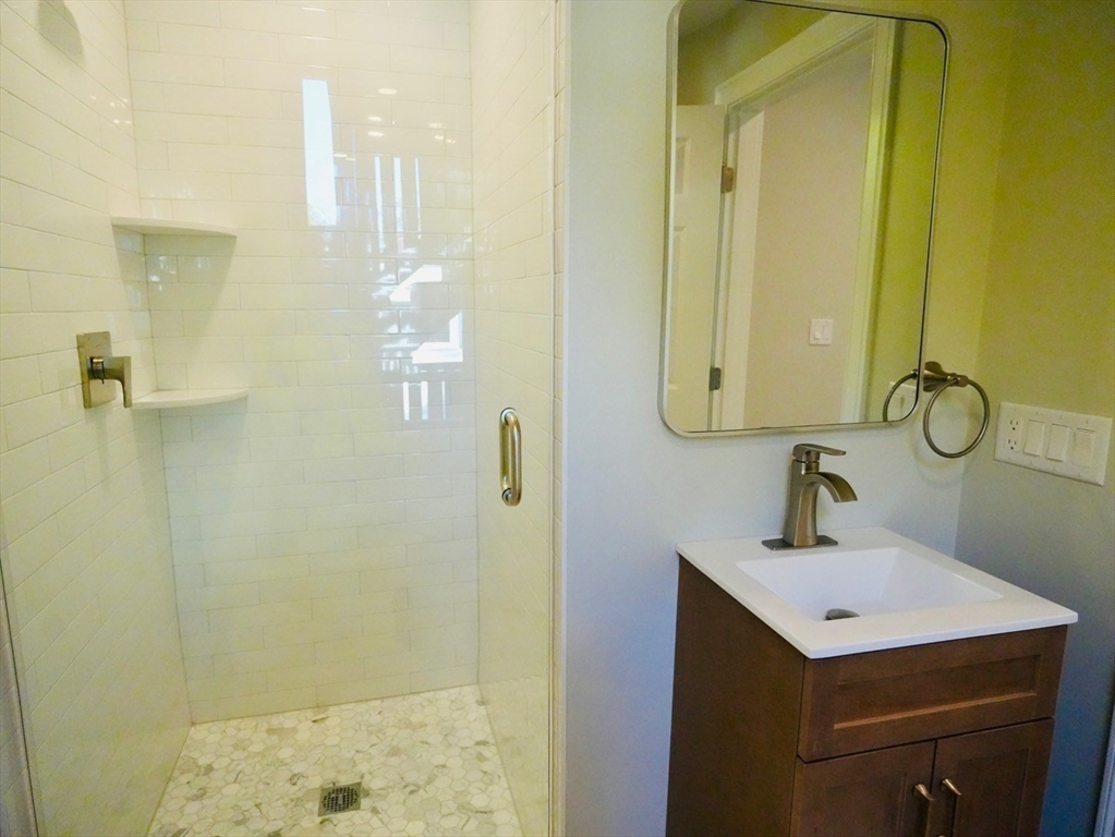 59 7th Street, Unit 3 Cambridge, MA 02141 - Photo 14 of 16 a bathroom with a sink a mirror and shower