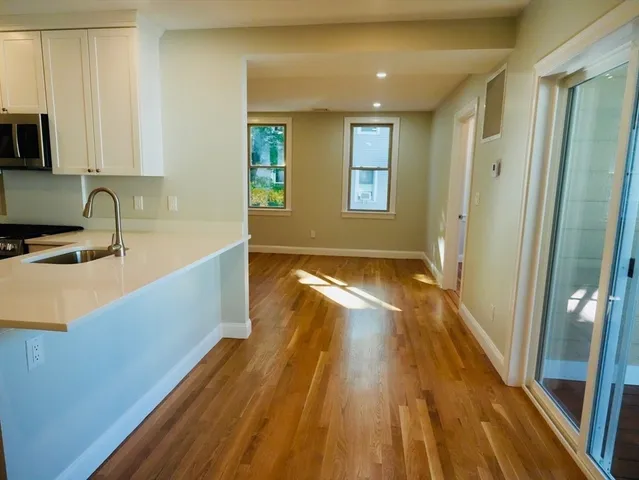 a view of a kitchen with wooden floor and a sink