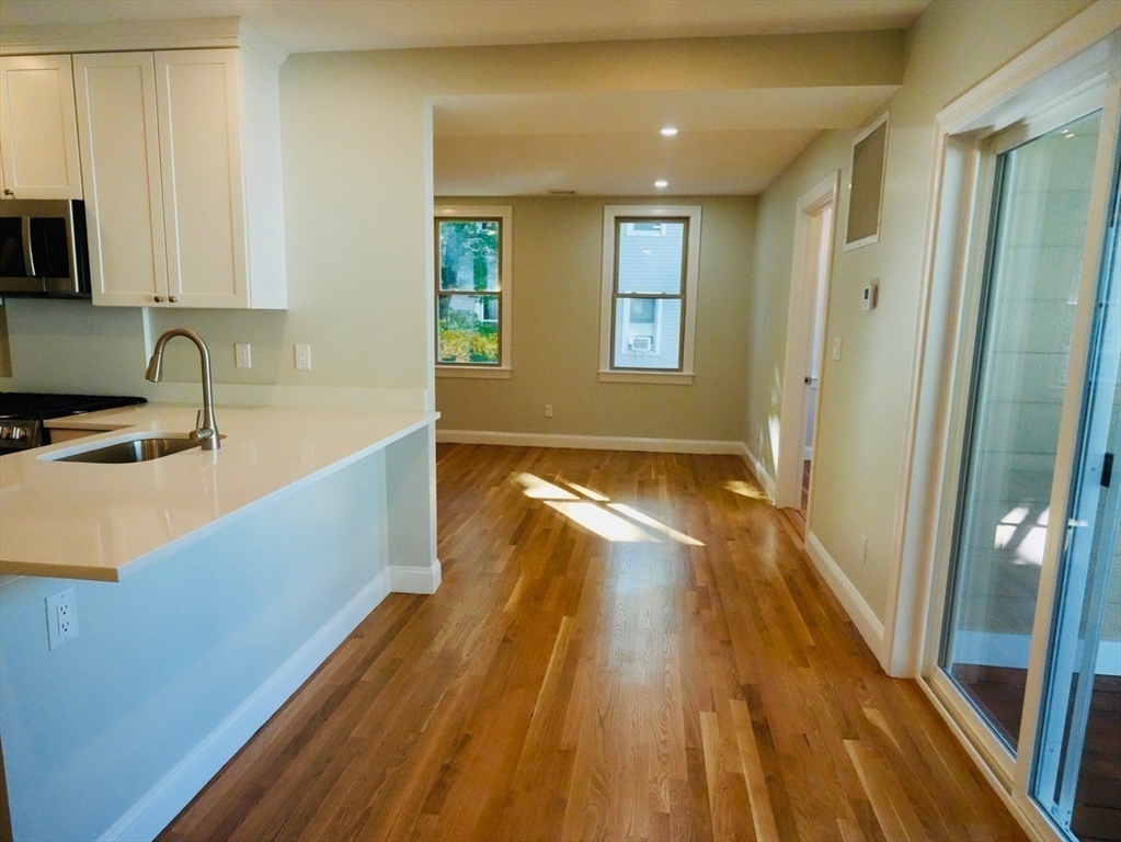 59 7th Street, Unit 3 Cambridge, MA 02141 - Photo 7 of 16 a view of a kitchen with wooden floor and a sink