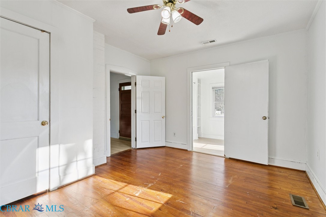 2290 Hayes Road Hayes, VA 23072 - Photo 19 of 32 Unfurnished bedroom with ensuite bathroom, light wood-style floors, crown molding, and ceiling fan