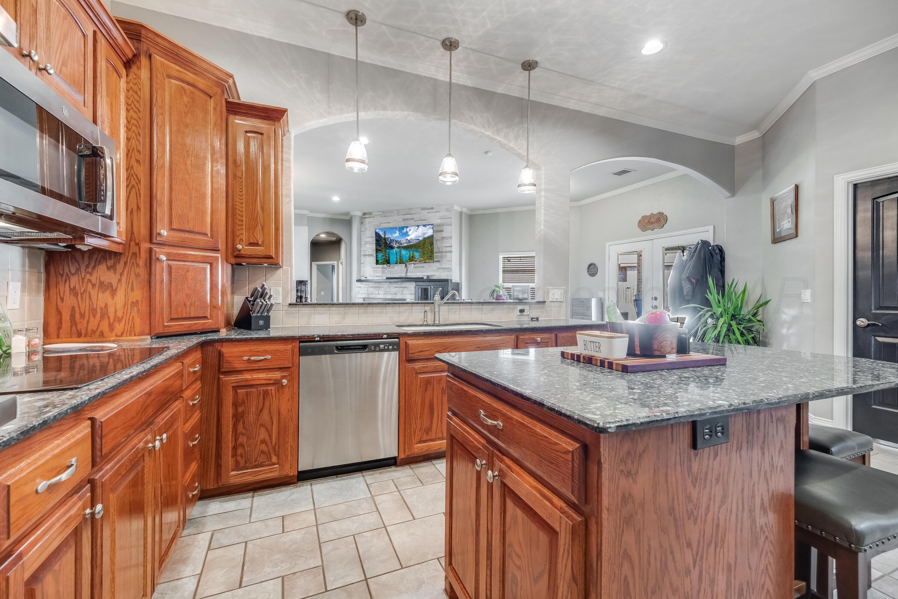 8413 Hamilton Drive Amarillo, TX 79119 - Photo 12 of 54 a kitchen with stainless steel appliances granite countertop a sink a stove a counter space and cabinets